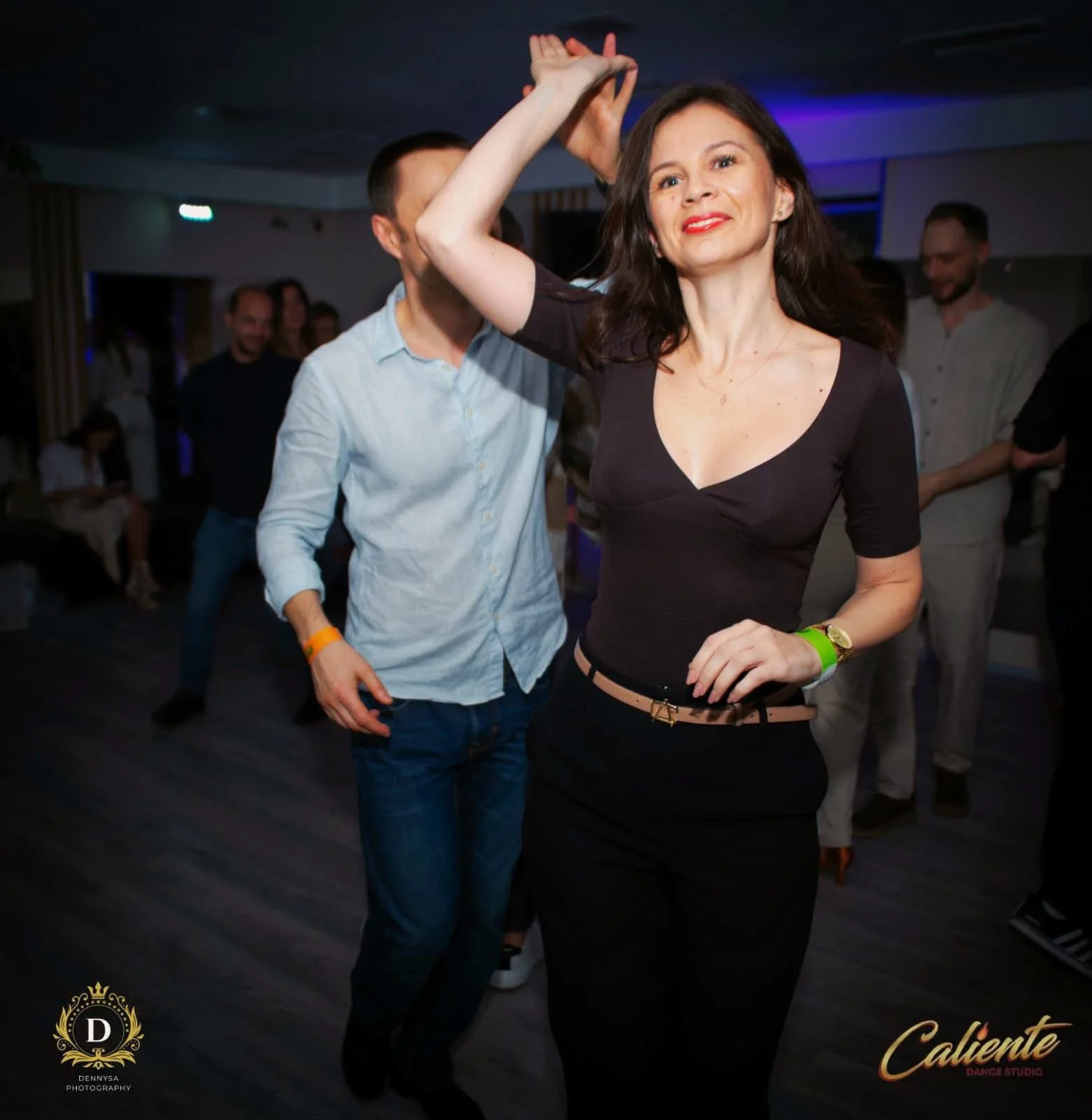 Copii participă cu entuziasm la o clasă de dans, zâmbind și mișcându-se energic, reflectând bucuria și energia învățării dansului.