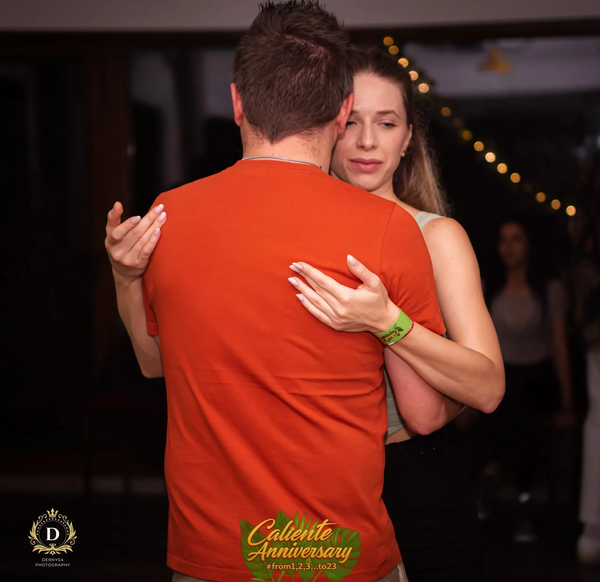 Grup de oameni dansând, lumini calde, atmosferă de petrecere latino